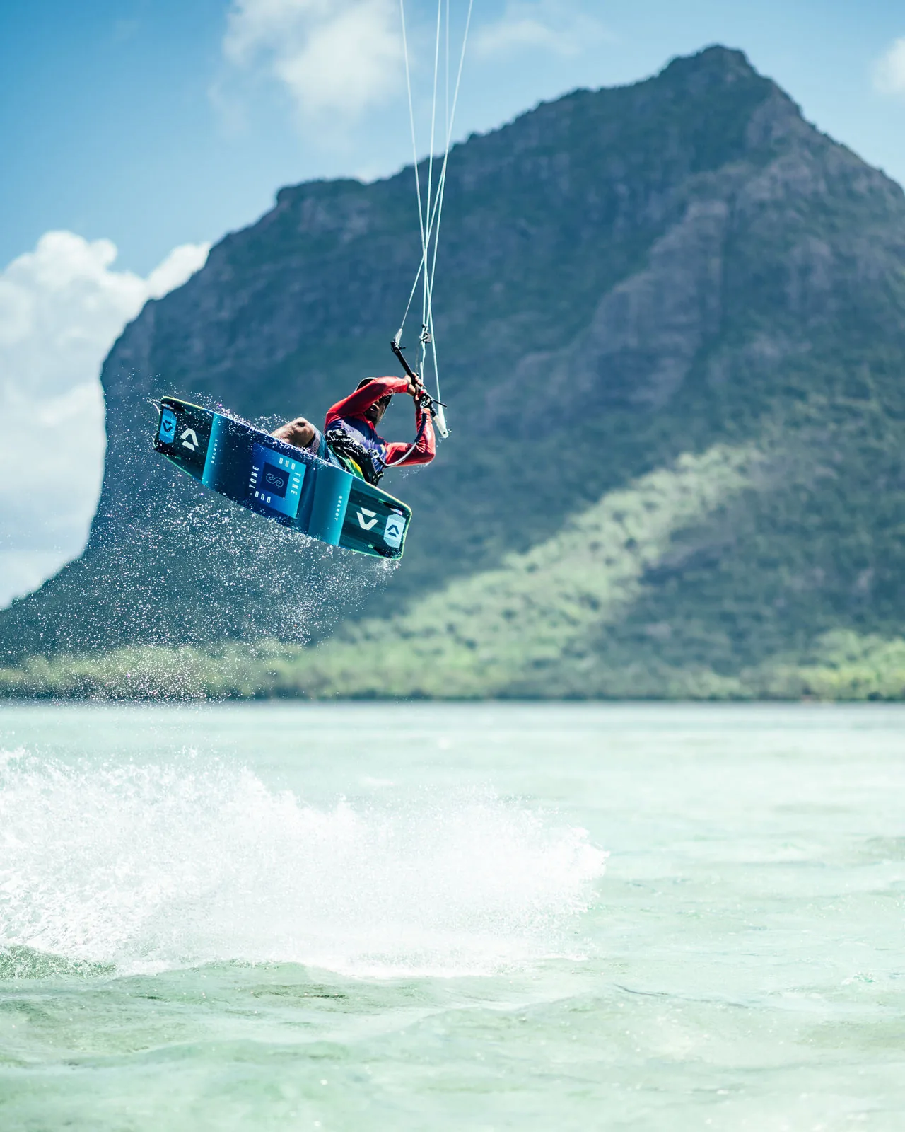 Un kitesurfeur effectue un saut devant la montagne du Morne