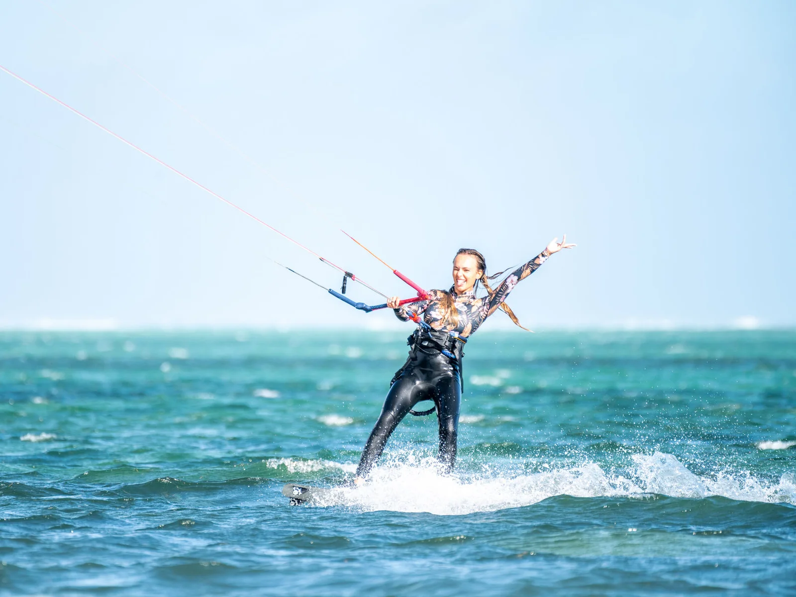 Kitesurfeuse souriante naviguant dans le lagon du Morne